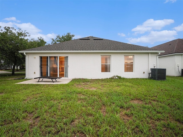 rear view of property with a patio area, central AC, a yard, and stucco siding