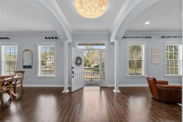 foyer entrance with a chandelier, dark hardwood / wood-style flooring, a wealth of natural light, and crown molding