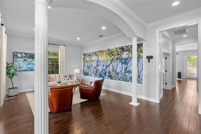 living area featuring ornamental molding, dark hardwood / wood-style floors, ornate columns, and a healthy amount of sunlight