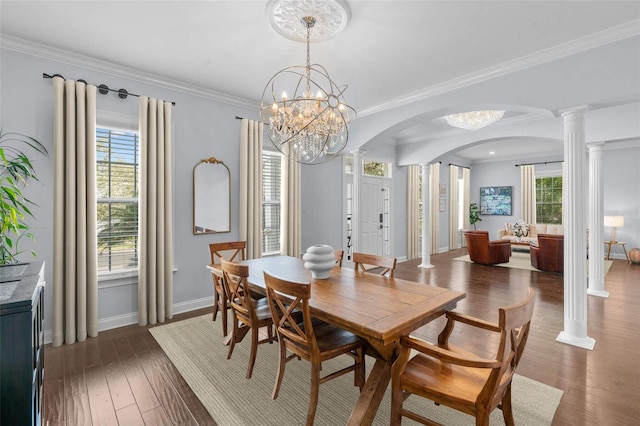 dining room featuring ornamental molding, ornate columns, dark wood-type flooring, and a notable chandelier