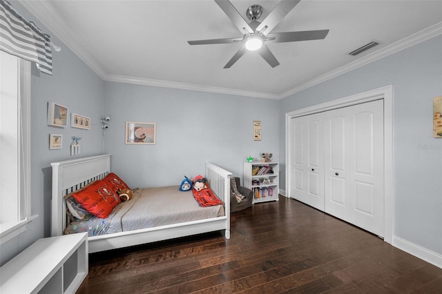 bedroom with ceiling fan, dark hardwood / wood-style floors, ornamental molding, and a closet