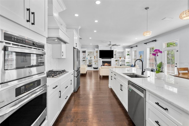 kitchen with white cabinets, appliances with stainless steel finishes, pendant lighting, and sink