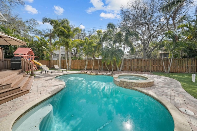 view of swimming pool featuring an in ground hot tub, a patio area, and a wooden deck