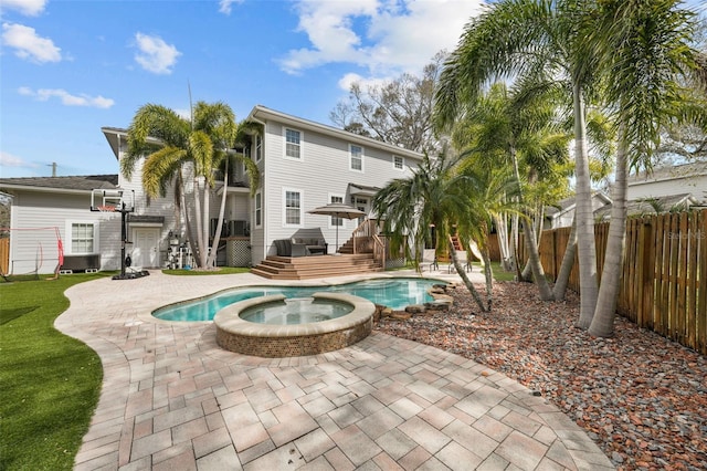 view of pool featuring an in ground hot tub, a deck, and a patio area