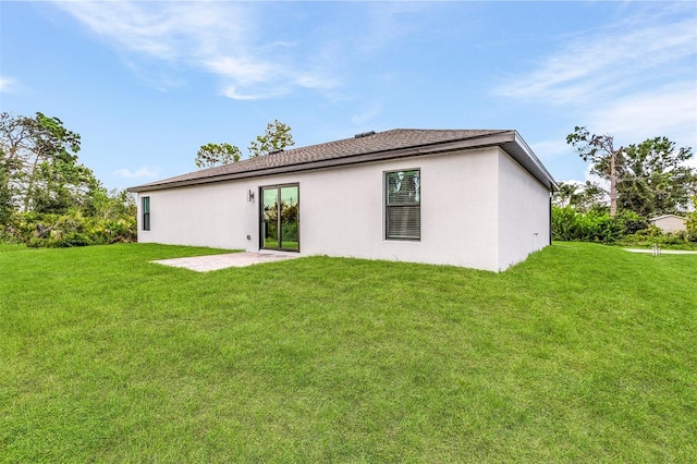 back of property with a lawn and a patio