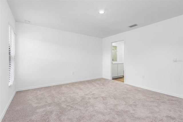 unfurnished room featuring light colored carpet