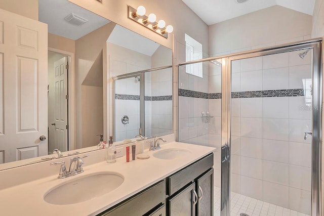 bathroom featuring double sink, oversized vanity, and a shower with door