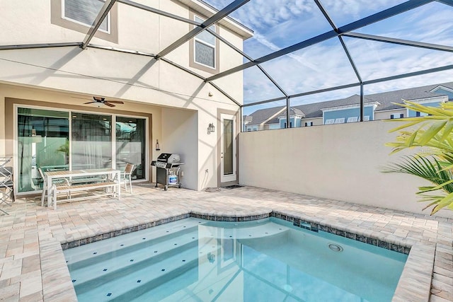 view of pool with area for grilling, a lanai, ceiling fan, and a patio