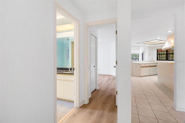 corridor featuring light hardwood / wood-style flooring and sink