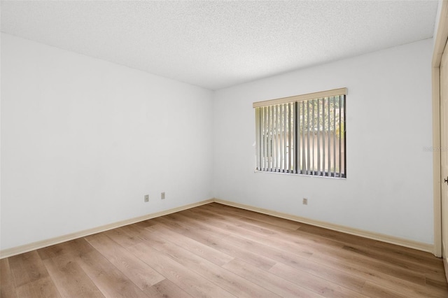 empty room featuring light hardwood / wood-style flooring and a textured ceiling