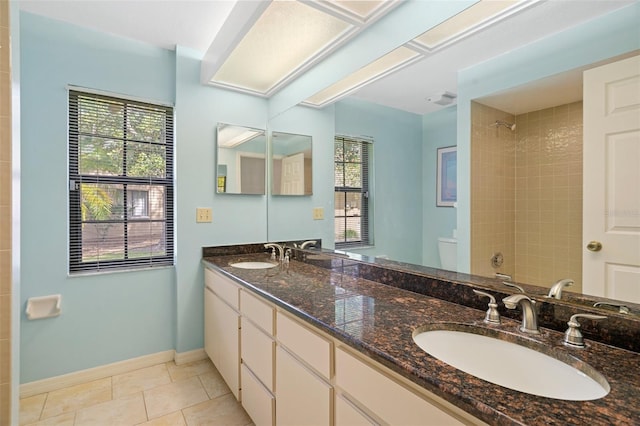 bathroom featuring double sink vanity, toilet, and tile floors