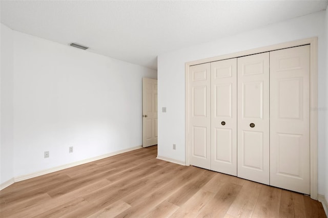 unfurnished bedroom featuring a closet and light hardwood / wood-style flooring