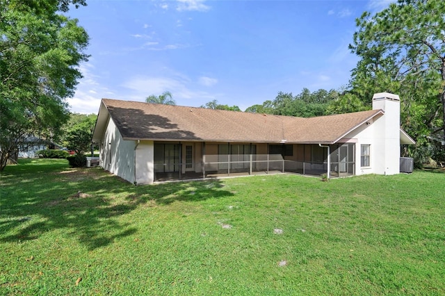 back of property featuring central AC, a lawn, and a sunroom