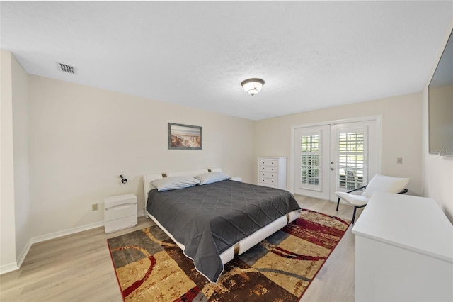 bedroom featuring light hardwood / wood-style flooring, french doors, and access to exterior