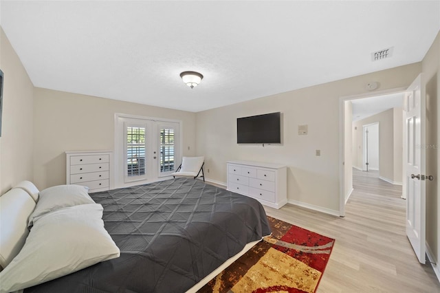 bedroom featuring french doors, light hardwood / wood-style flooring, and access to exterior