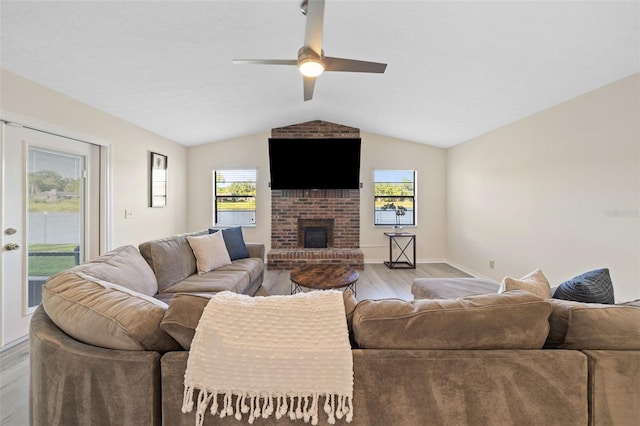 living room with plenty of natural light, vaulted ceiling, and light wood-type flooring