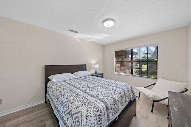 bedroom featuring a textured ceiling and dark wood-type flooring