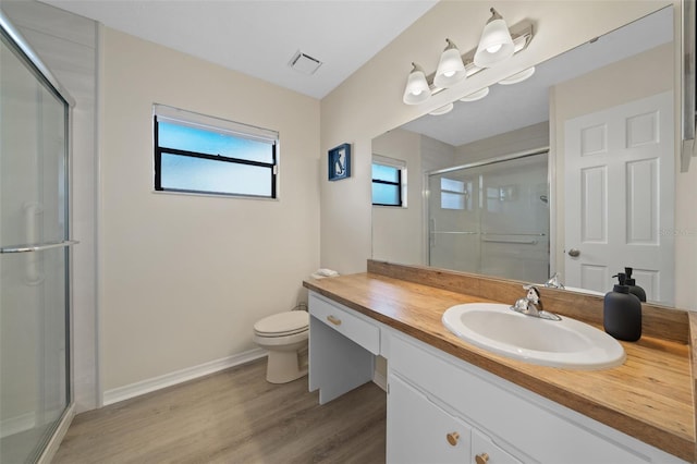 bathroom with an enclosed shower, toilet, vanity, and hardwood / wood-style floors