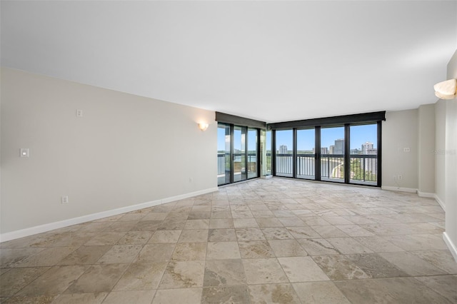 unfurnished room featuring a wall of windows