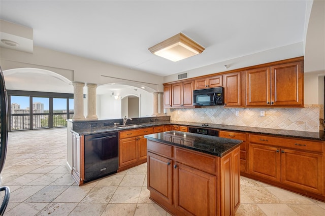 kitchen with dark stone countertops, sink, black appliances, and a kitchen island