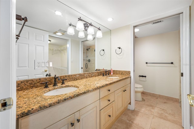 bathroom featuring vanity, a shower with shower door, tile patterned floors, and toilet