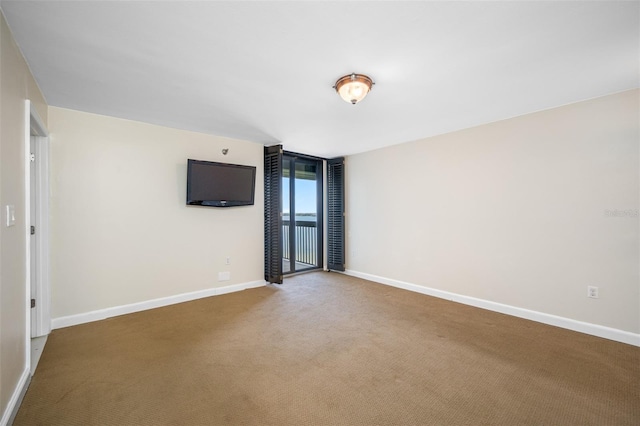 carpeted empty room featuring floor to ceiling windows