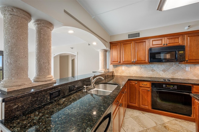 kitchen featuring sink, dark stone countertops, decorative columns, tasteful backsplash, and black appliances