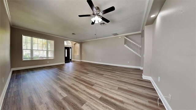 unfurnished living room with a textured ceiling, ornamental molding, wood-type flooring, and ceiling fan