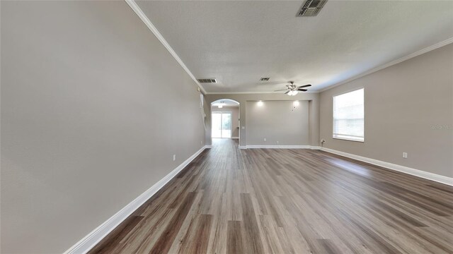 interior space featuring ceiling fan, dark wood-type flooring, a textured ceiling, and crown molding