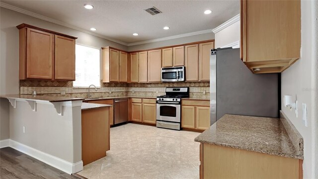 kitchen featuring light stone countertops, stainless steel appliances, backsplash, and sink