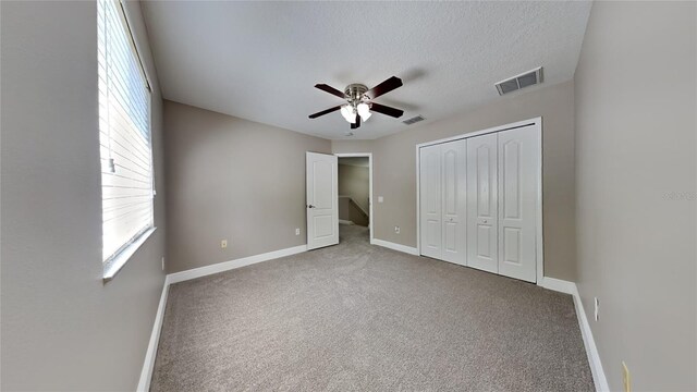 unfurnished bedroom with light colored carpet, ceiling fan, and multiple windows