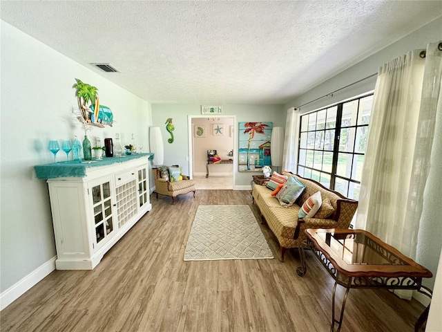 living area with light hardwood / wood-style flooring and a textured ceiling