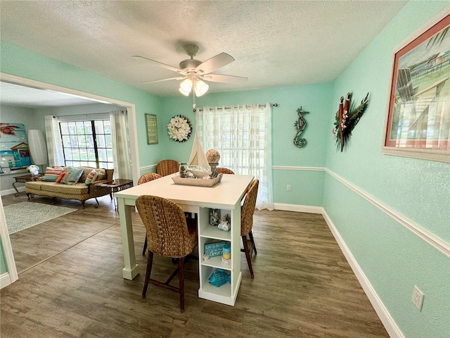 dining room featuring a textured ceiling, dark hardwood / wood-style floors, and ceiling fan