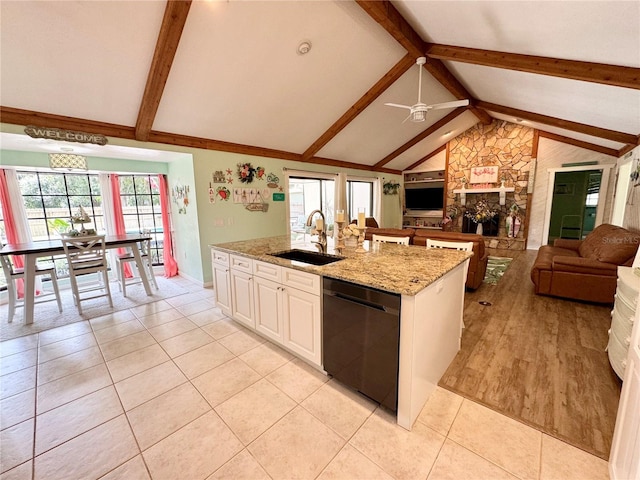 kitchen featuring dishwasher, lofted ceiling with beams, sink, light stone countertops, and light tile patterned flooring