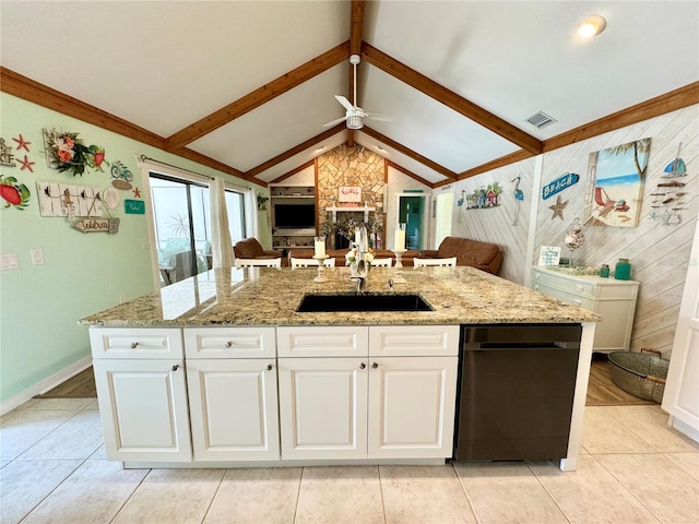 kitchen with ceiling fan, sink, vaulted ceiling with beams, a kitchen island with sink, and white cabinets