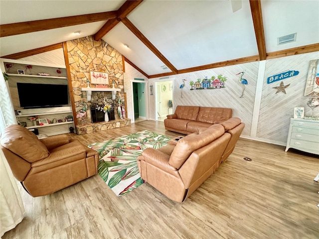 living room with vaulted ceiling with beams, a fireplace, and wood-type flooring