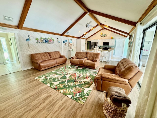 living room featuring ceiling fan, lofted ceiling with beams, and light wood-type flooring