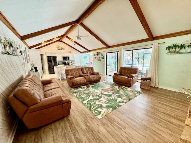 living room with hardwood / wood-style floors, vaulted ceiling with beams, and ceiling fan