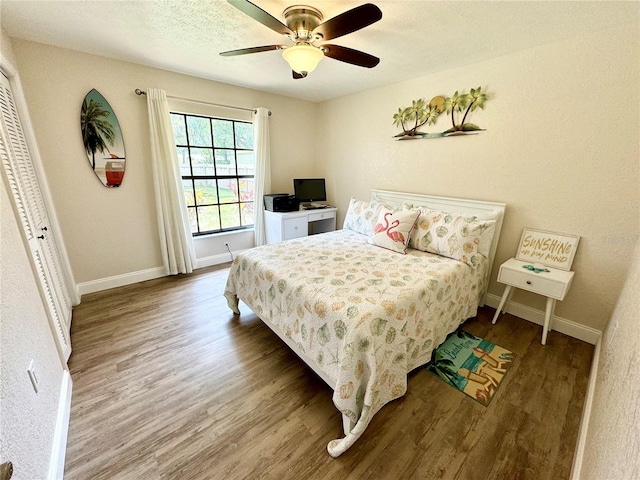 bedroom with wood-type flooring, a textured ceiling, a closet, and ceiling fan