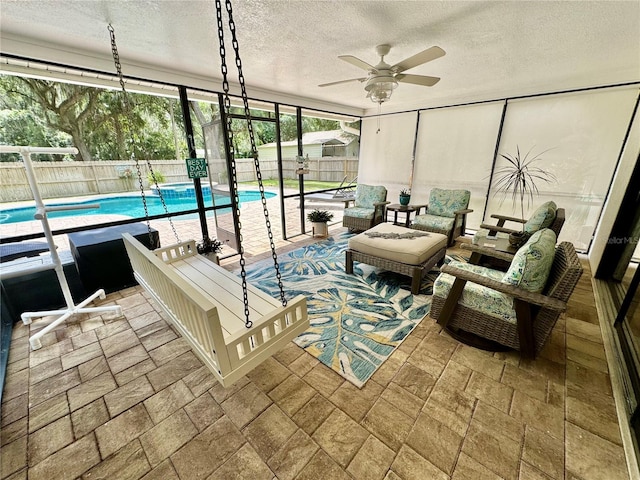 sunroom with a pool and ceiling fan