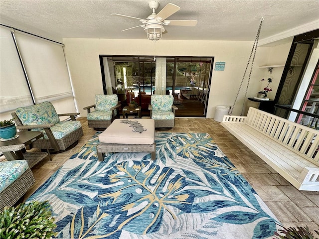 living room with ceiling fan and a textured ceiling