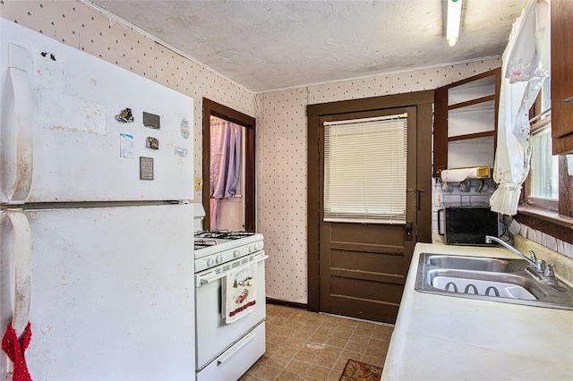 kitchen with white appliances, a textured ceiling, sink, and light tile flooring