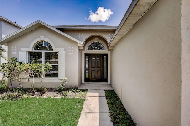 entrance to property featuring a lawn