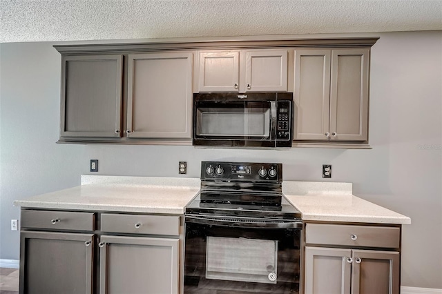 kitchen featuring a textured ceiling, black appliances, and gray cabinetry