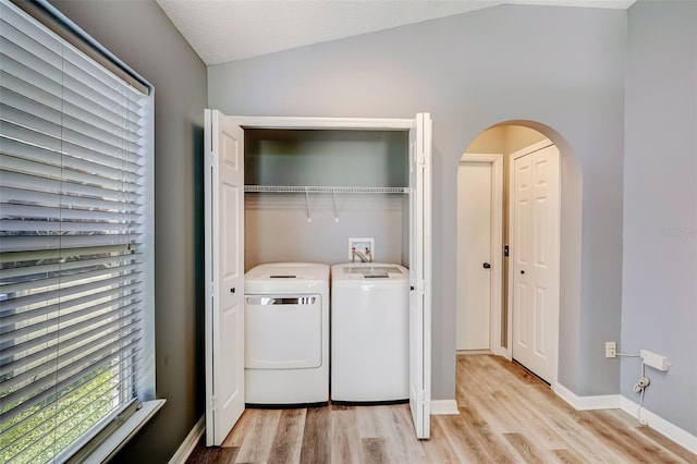 washroom with washing machine and clothes dryer, hookup for a washing machine, and light wood-type flooring