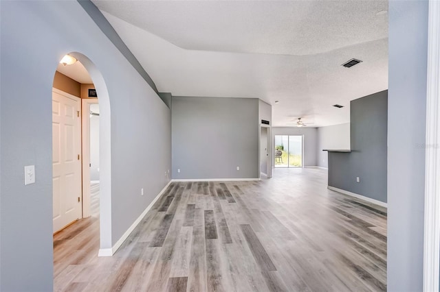 unfurnished living room with light hardwood / wood-style floors, a textured ceiling, and ceiling fan