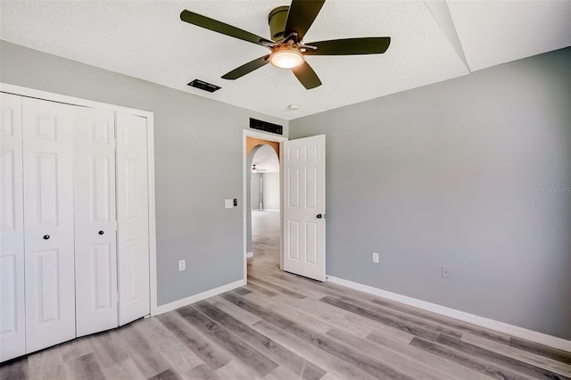 unfurnished bedroom with a closet, ceiling fan, and light wood-type flooring