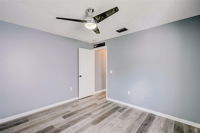 unfurnished room featuring a textured ceiling, ceiling fan, and light wood-type flooring