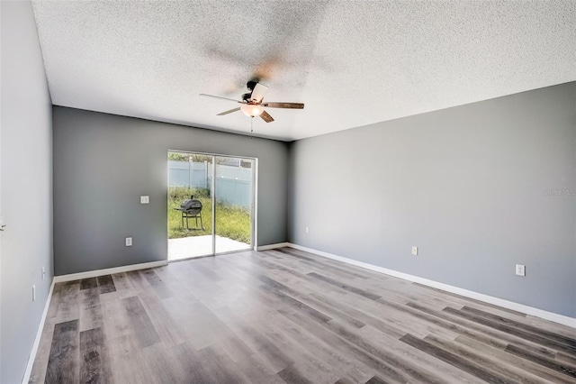 empty room featuring dark wood-type flooring, ceiling fan, and a textured ceiling