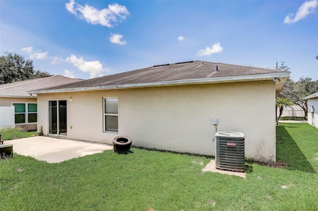 back of house with central AC unit, a patio area, and a yard